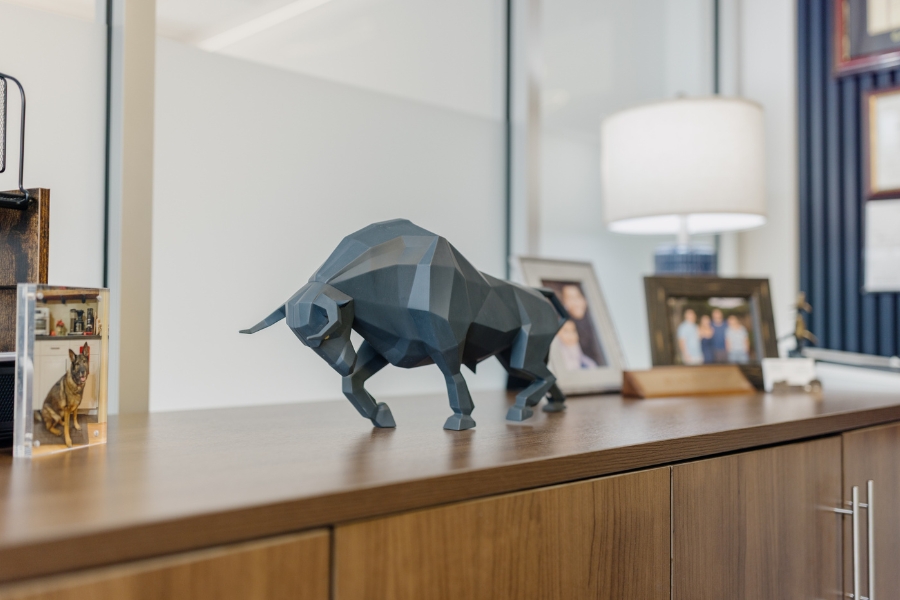 A modern geometric bull sculpture, a symbol of the stock market, displayed in Phases Financial Group's office.