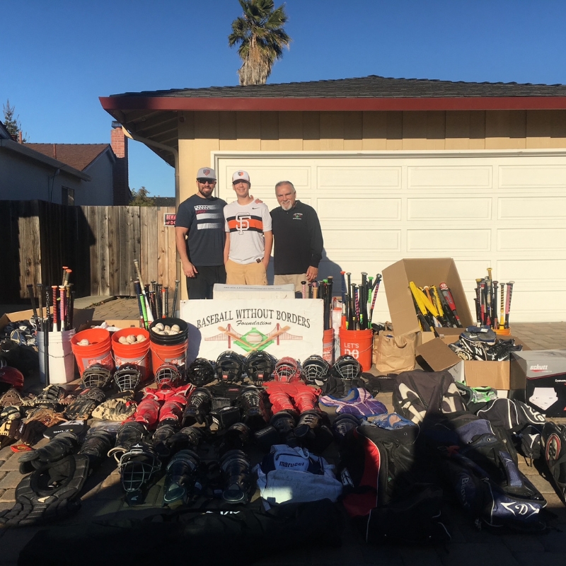 The Phases Financial Group poses with some of the equipment they've put together in a communty drive for Baseball Without Borders
