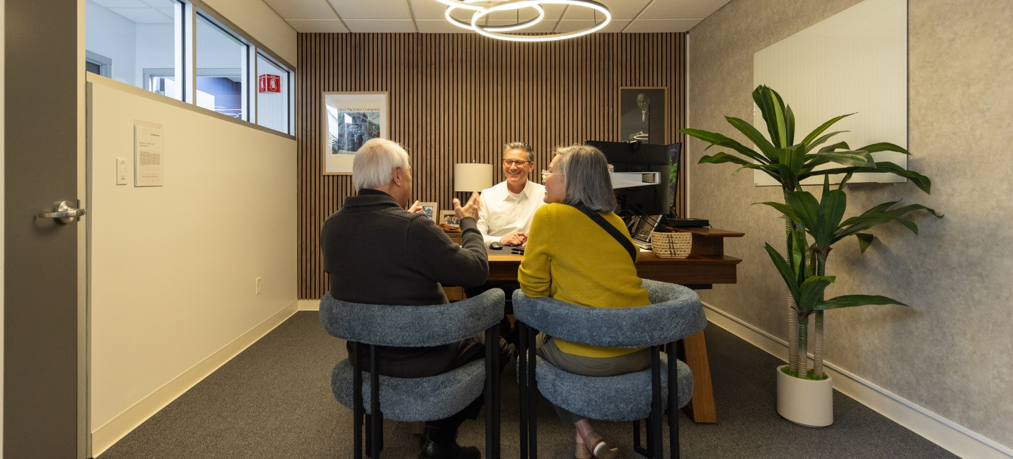 A Phases Financial Group financial advisor meets with a retired couple in the firm's Palo Alto, CA office to discuss their financial planning.