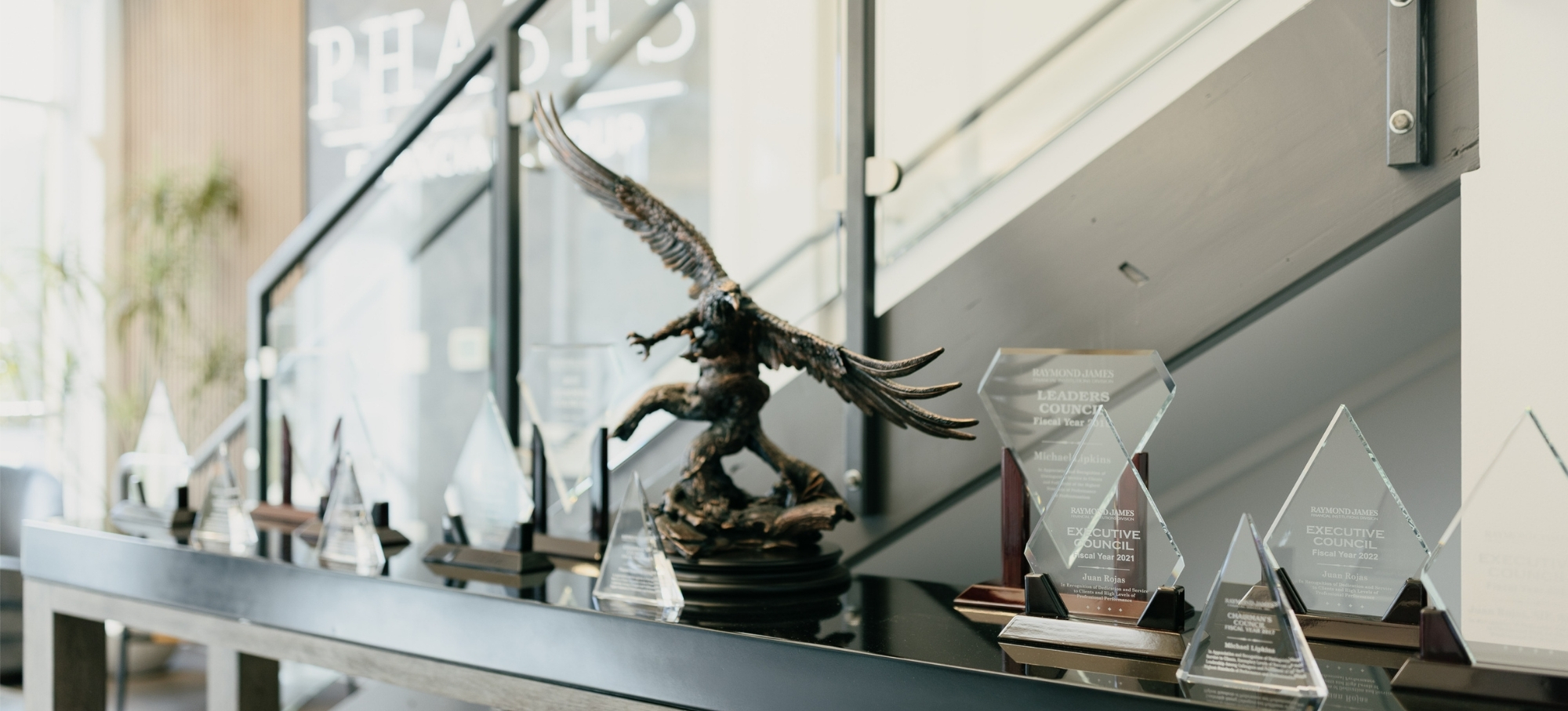 Industry-recognition awards and trophies displayed in Phases Financial Group's Palo Alto office, honoring the firm's Financial Advisors.