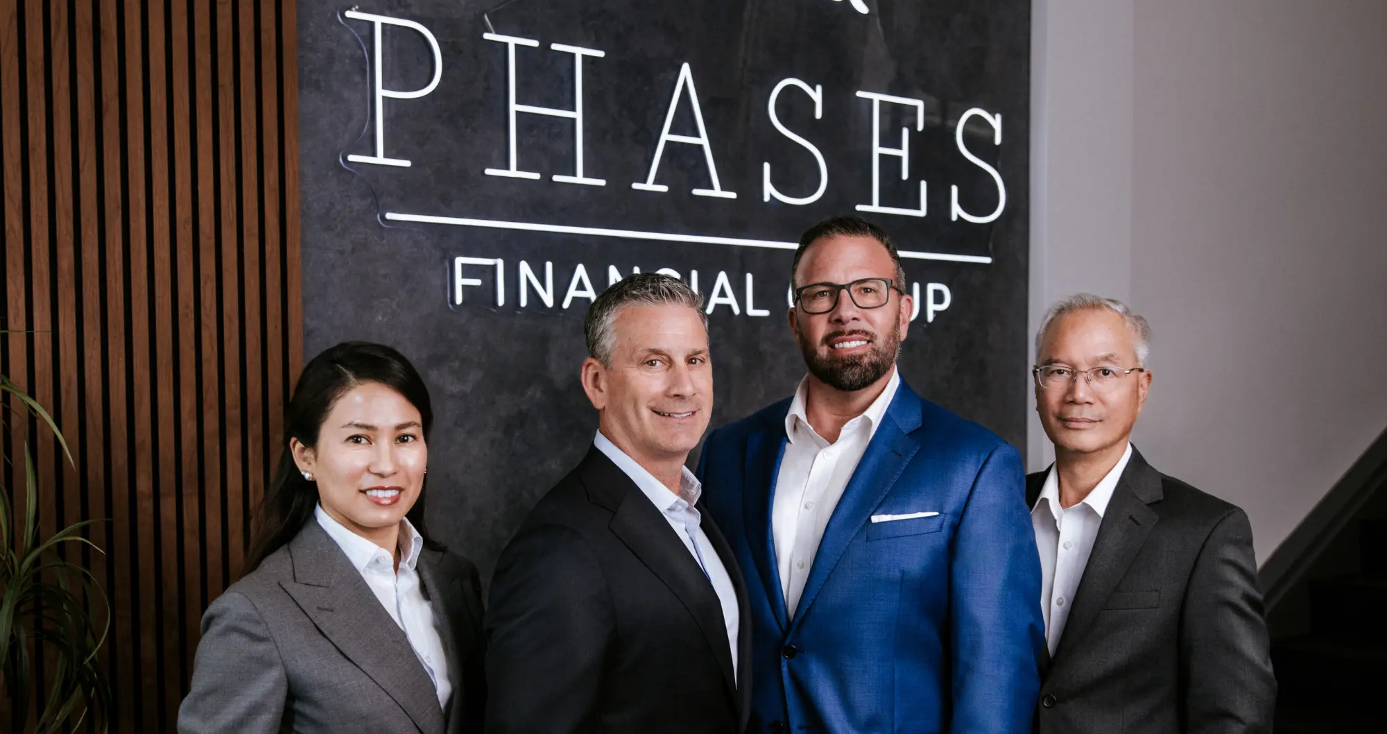 Ianna Huang, Michael Lipkins, Juan Rojas, and Victor Navalta, the Financial Advisors and Partners of Phases Financial Group, standing together in their Palo Alto, CA office.